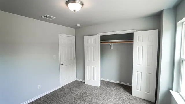 a bathroom with a granite countertop toilet sink and mirror