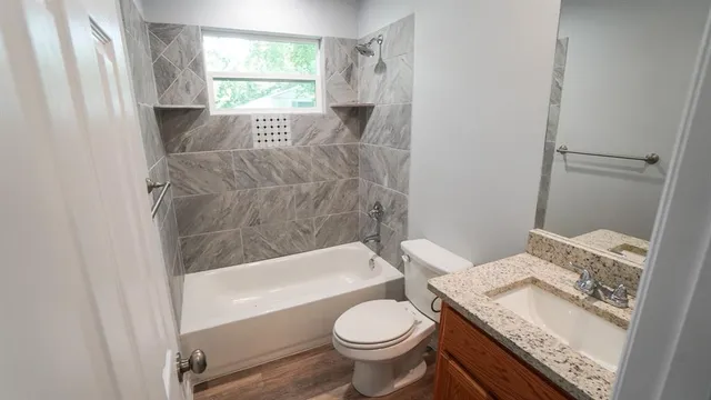 a white toilet sitting next to a wooden floor