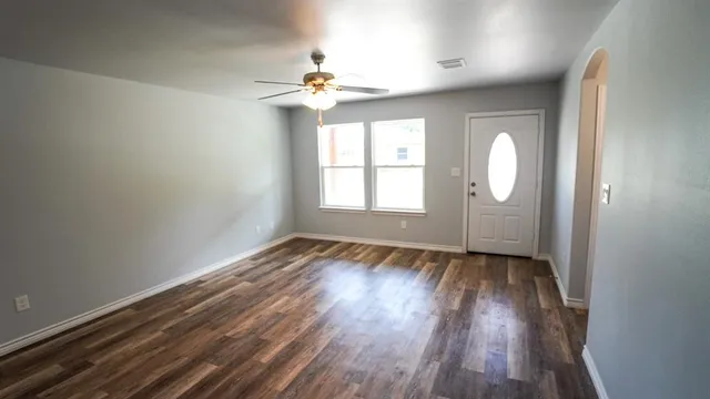 wooden floor in an empty room with a window
