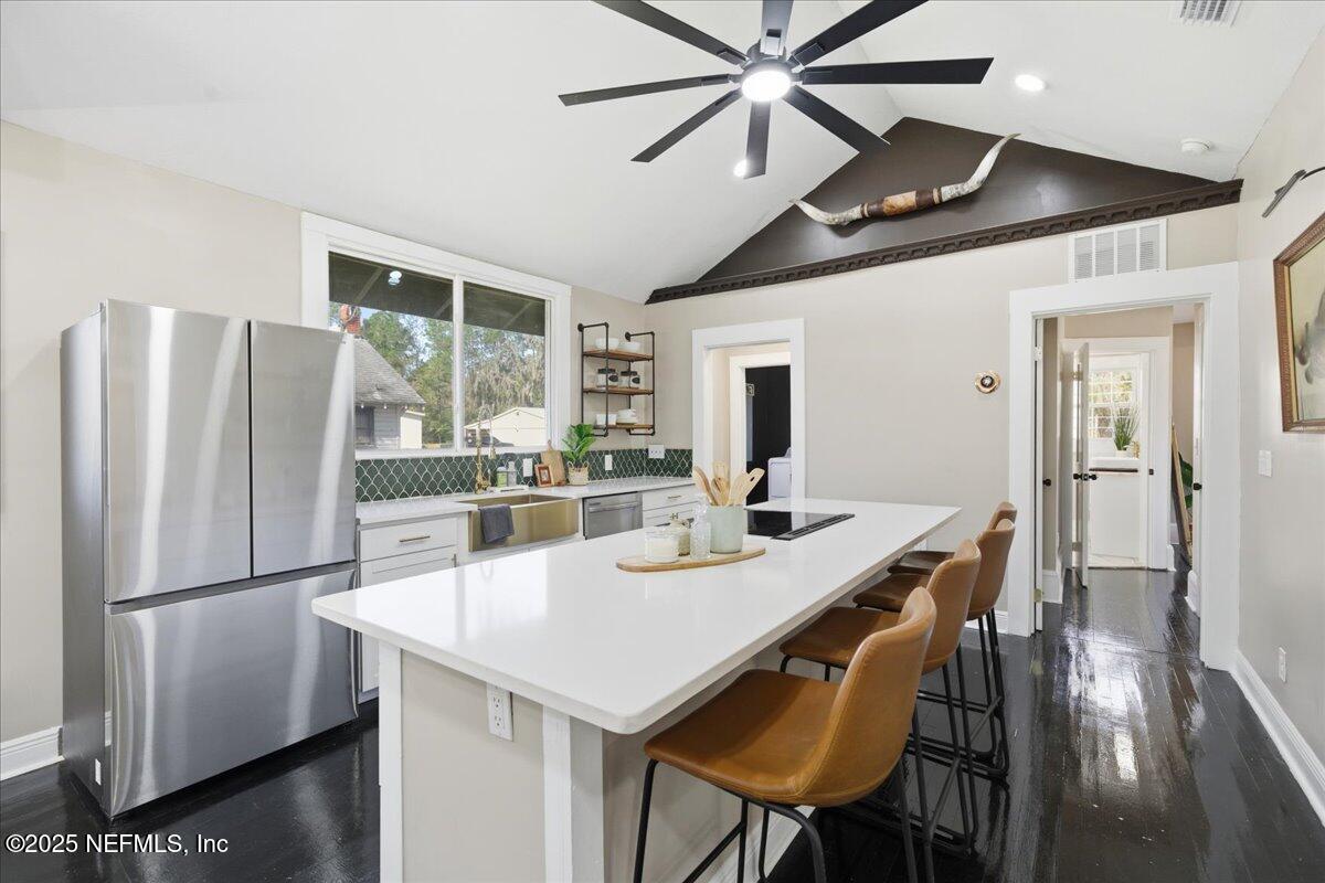 9671 Old Plank Road Jacksonville, FL 32220 - Photo 14 of 62 a kitchen with stainless steel appliances granite countertop a dining table chairs and refrigerator