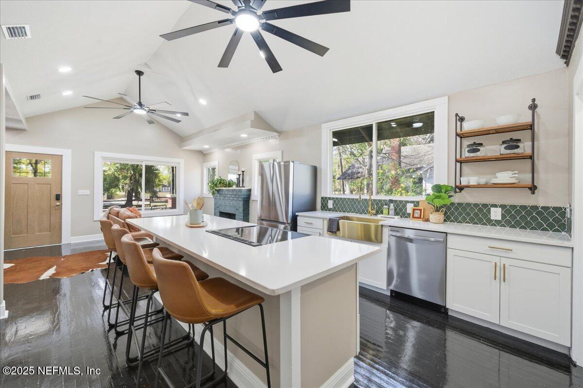 9671 Old Plank Road Jacksonville, FL 32220 - Photo 15 of 62 a kitchen with stainless steel appliances kitchen island a chandelier and wooden cabinets
