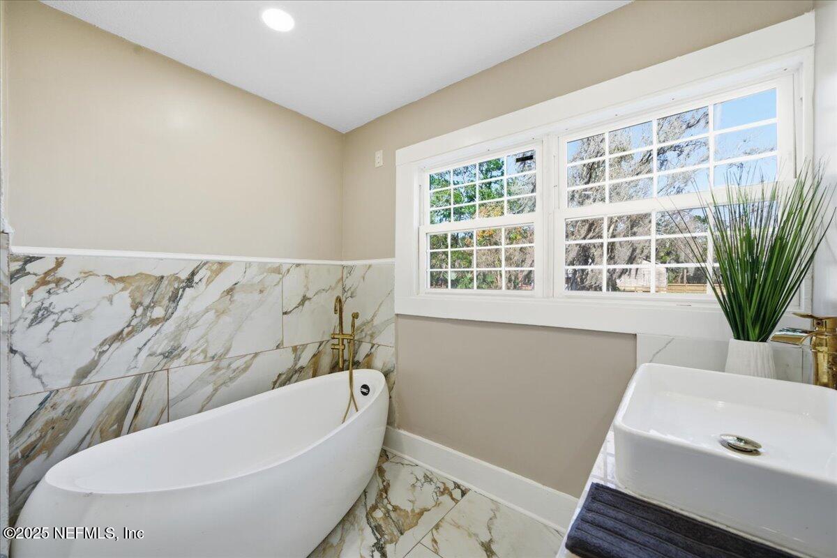 9671 Old Plank Road Jacksonville, FL 32220 - Photo 24 of 62 a bathroom with a bathtub and window