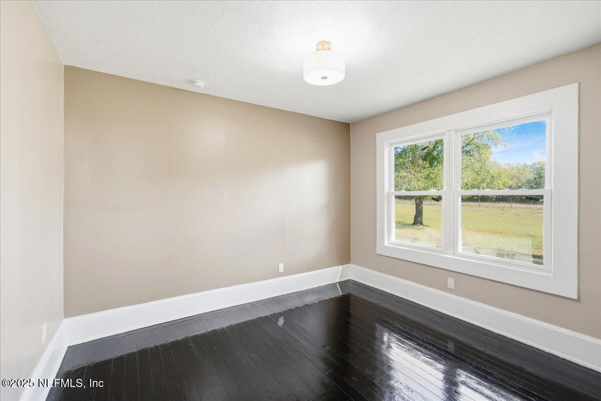 9671 Old Plank Road Jacksonville, FL 32220 - Photo 31 of 62 a view of an empty room with wooden floor and a window