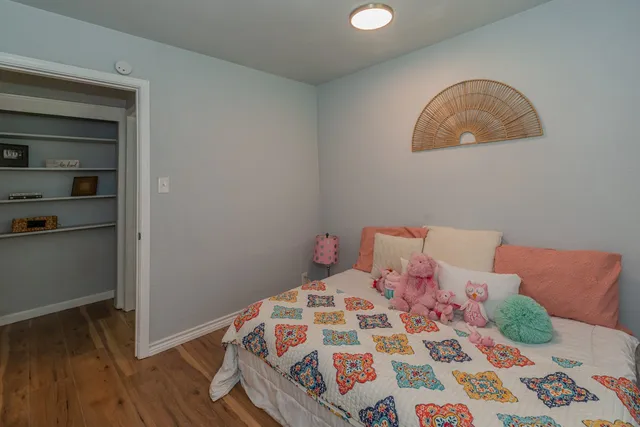 a bedroom with a bed and a wooden floor