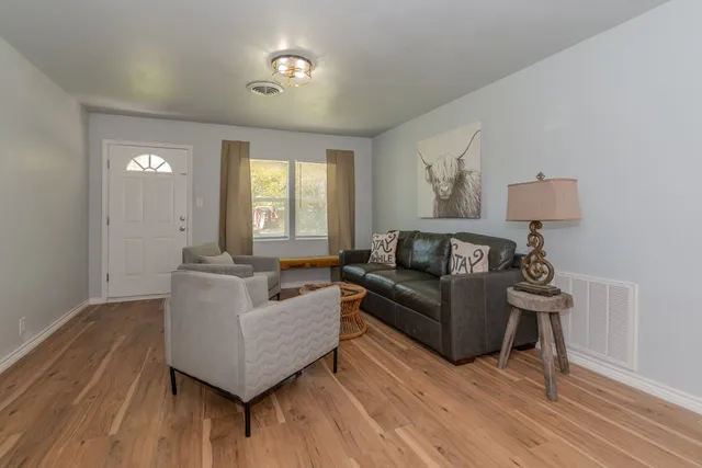 a living room with furniture and a wooden floor