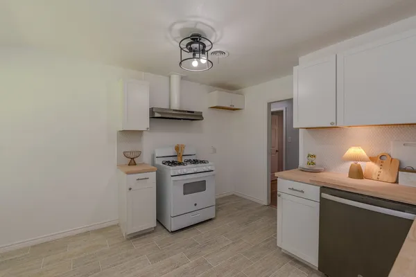 a kitchen with stainless steel appliances a sink stove and cabinets