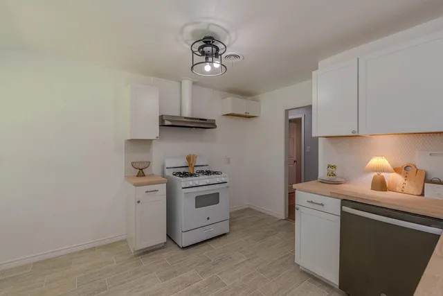 a kitchen with stainless steel appliances a sink stove and cabinets