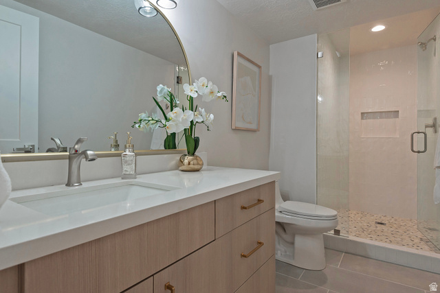 16 Gatehouse Lane Sandy, UT 84092 - Photo 45 of 73 Bathroom featuring a shower stall, vanity, and light tile patterned floors