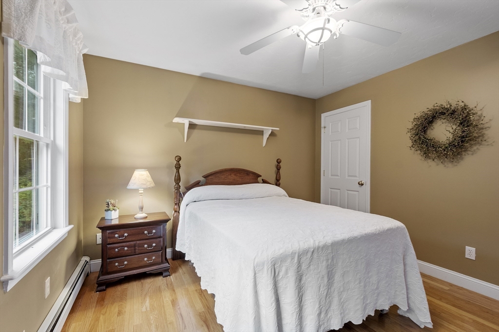 74 King Road Charlton, MA 01507 - Photo 25 of 38 a bedroom with a bed and a chandelier