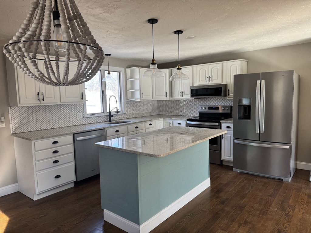 86 East Main Street Ayer, MA 01432 - Photo 4 of 35 a kitchen with stainless steel appliances granite countertop a sink a stove and refrigerator