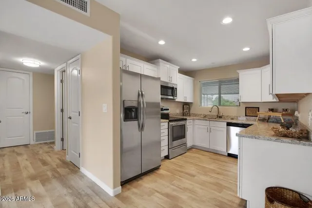 a kitchen with refrigerator a sink and a stove top oven