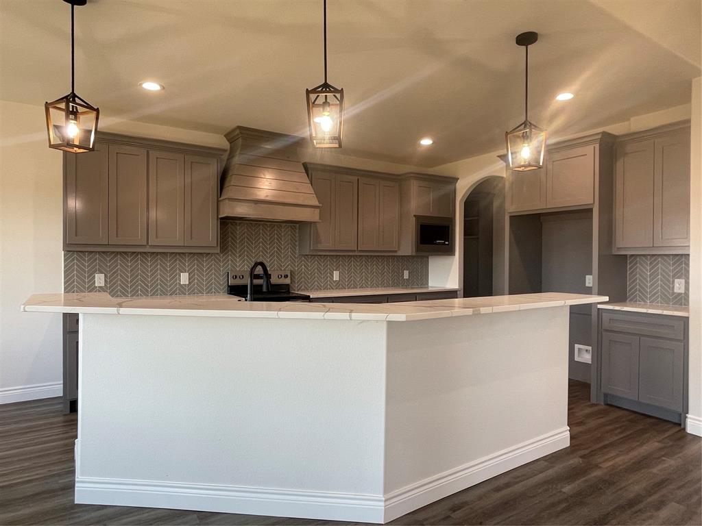 35 Old Sanborn Ranch Road Whitesboro, TX 76273 - Photo 2 of 9 a kitchen with stainless steel appliances granite countertop a sink a refrigerator a center island a stove and white cabinets with wooden floor