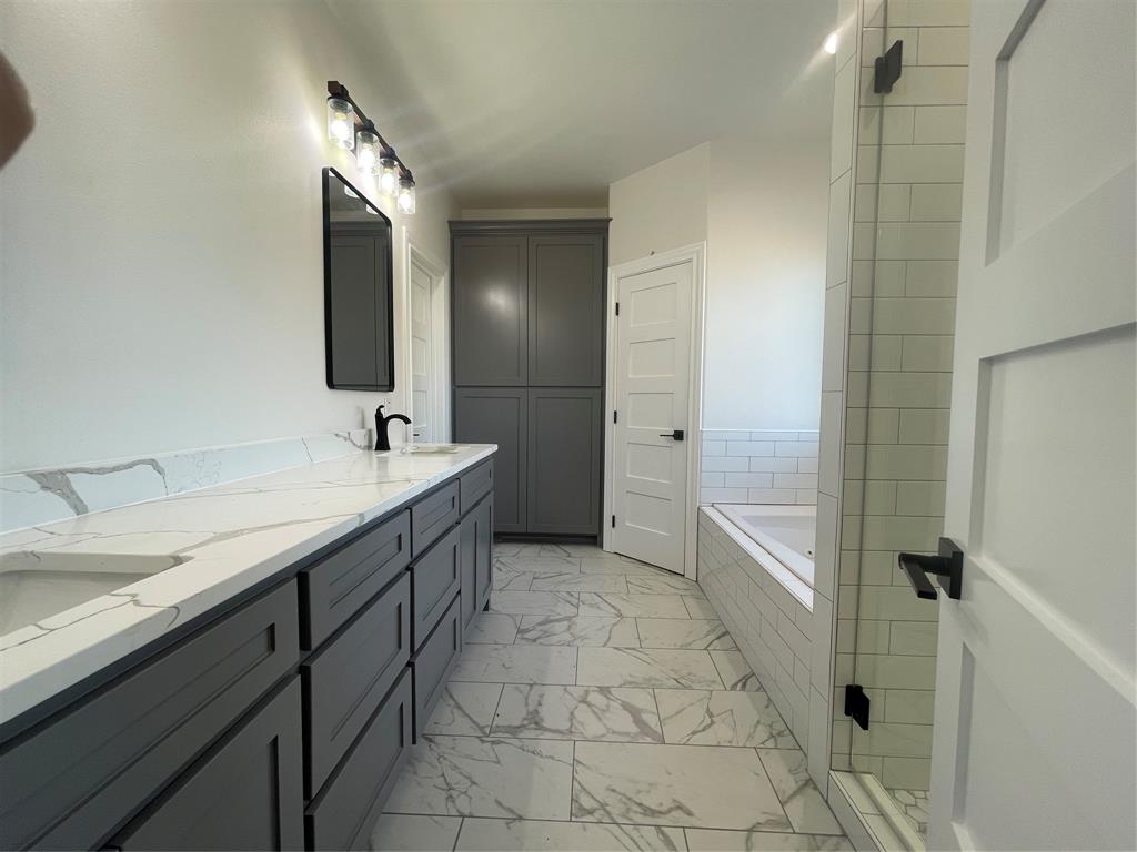 35 Old Sanborn Ranch Road Whitesboro, TX 76273 - Photo 9 of 9 a spacious bathroom with a granite countertop sink mirror and bathtub