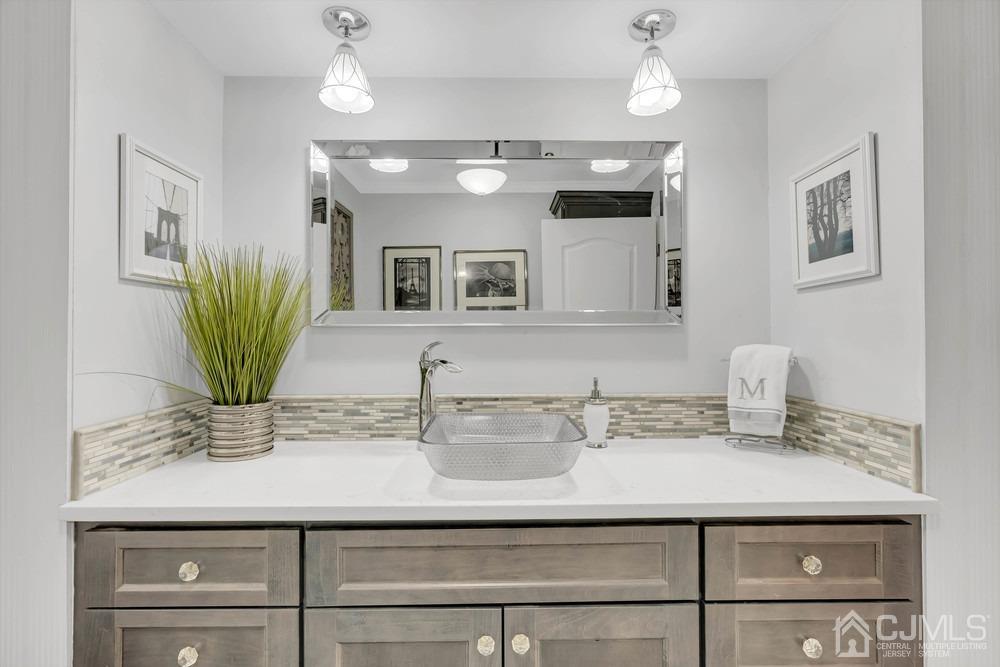 24 Crabtree Road Old Bridge, NJ 07747 - Photo 22 of 47 a bathroom with a sink a mirror and a potted plant