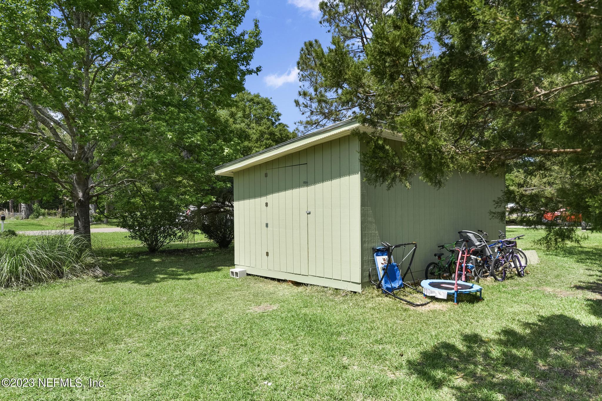 54042 Vikki Road Callahan, FL 32011 - Photo 27 of 31 a view of a backyard with a barn and a large tree
