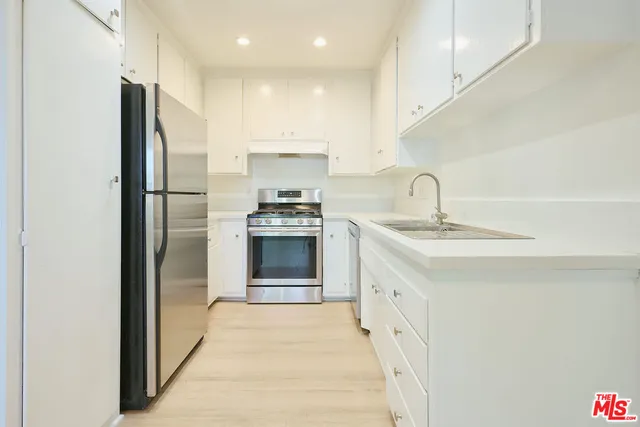 a kitchen with kitchen island a sink stainless steel appliances and cabinets