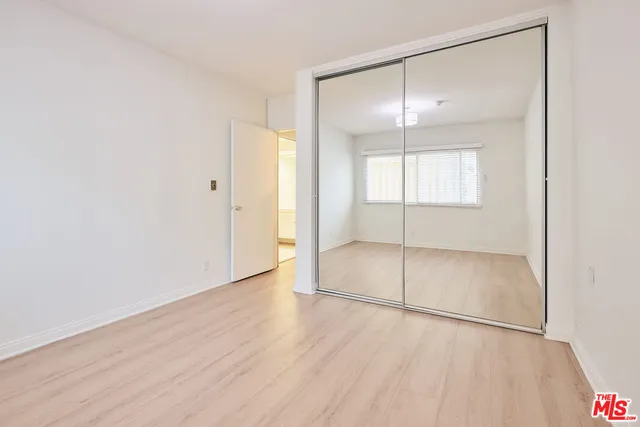 an empty room with wooden floor and sliding door