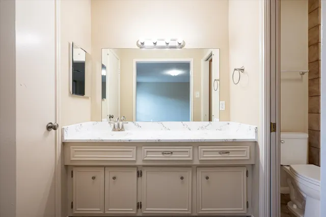 a bathroom with a granite countertop sink toilet and shower