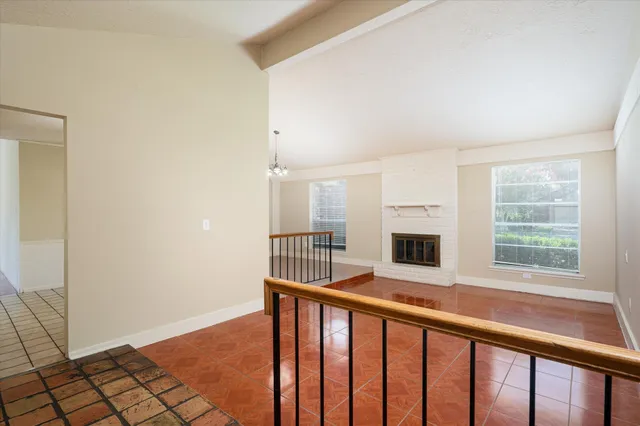 a view of an empty room with a window and fire place