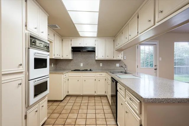 a kitchen with granite countertop a sink and cabinets