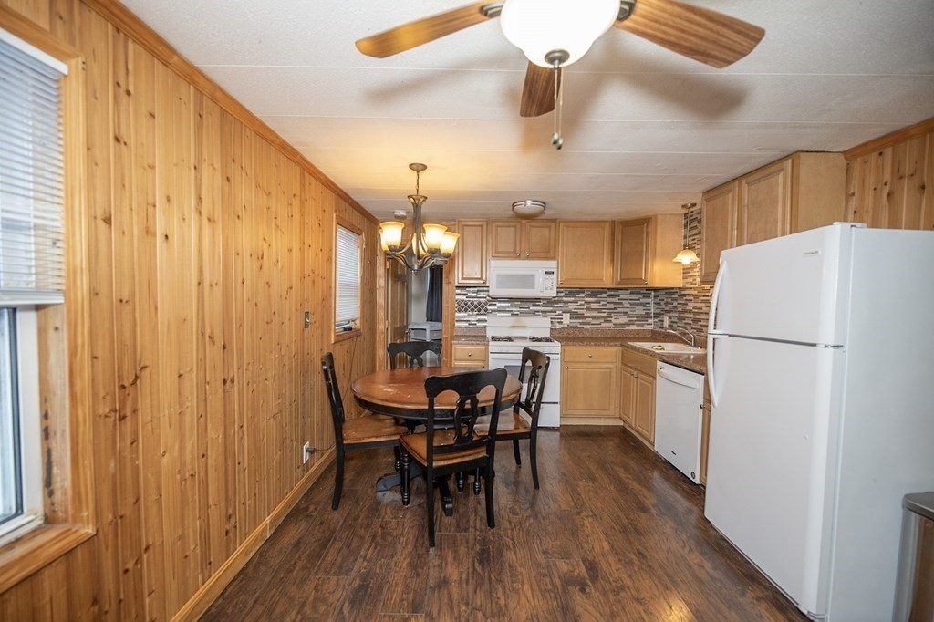 200 North Street, Unit 16C Danvers, MA 01923 - Photo 3 of 8 a kitchen with a refrigerator a dining table and chairs