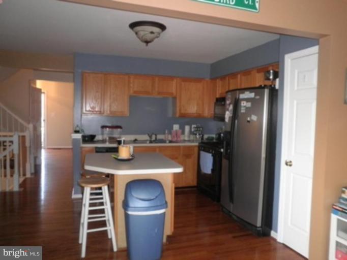 4085 Jasper Loop Dumfries, VA 22025 - Photo 3 of 15 a kitchen with a refrigerator a stove and a microwave oven