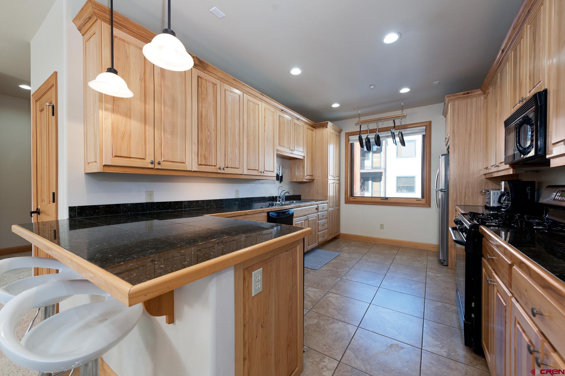1422 Animas View Drive, Unit 55 Durango, CO 81301 - Photo 11 of 44 a kitchen with a stove a sink and a microwave