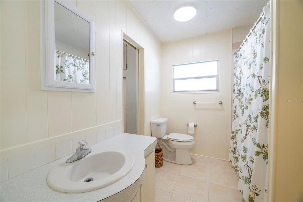 10011 110th Place, Unit 246 Largo, FL 33773 - Photo 13 of 31 a bathroom with a toilet sink and mirror