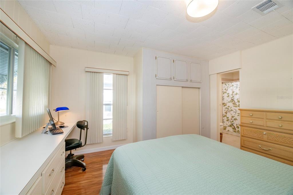 10011 110th Place, Unit 246 Largo, FL 33773 - Photo 15 of 31 a bedroom with a bed and wooden floor