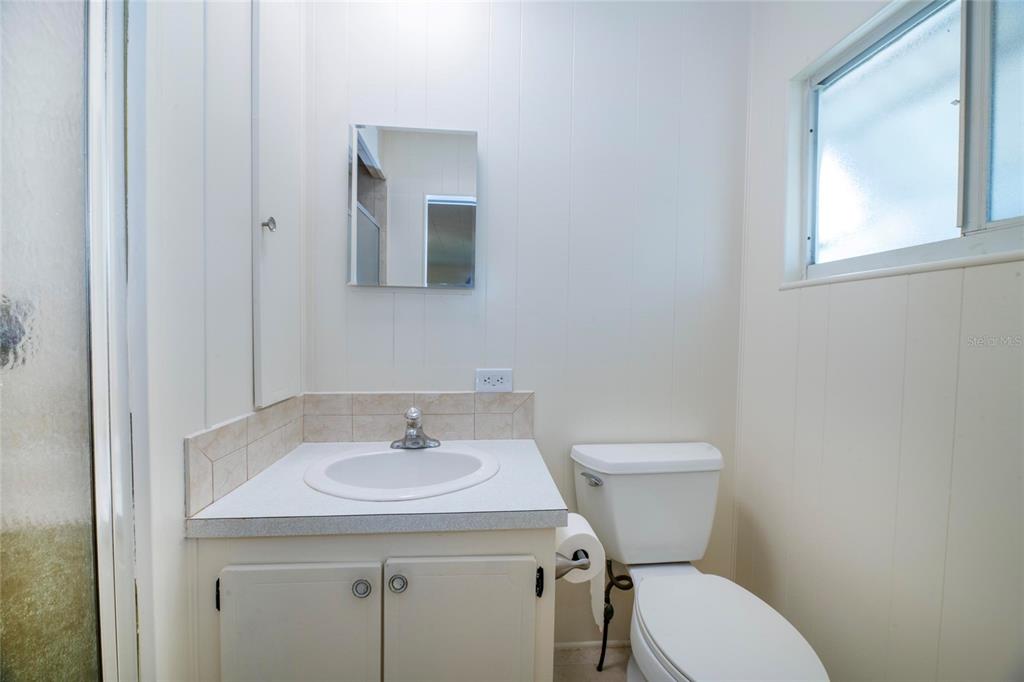10011 110th Place, Unit 246 Largo, FL 33773 - Photo 17 of 31 a bathroom with a toilet sink and mirror