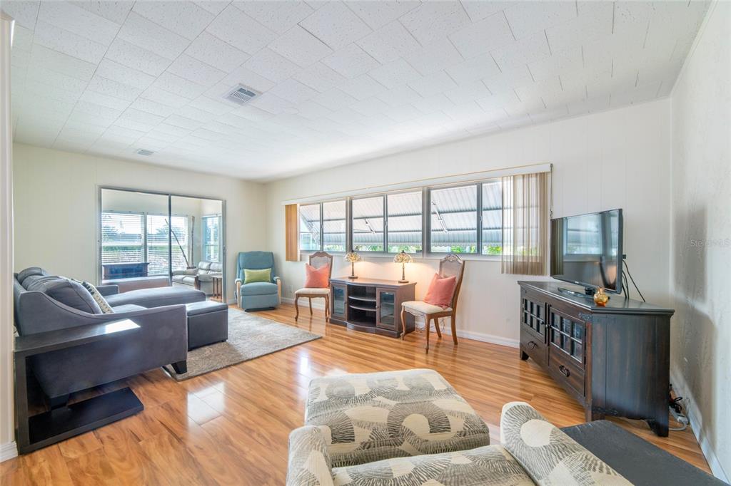 10011 110th Place, Unit 246 Largo, FL 33773 - Photo 6 of 31 a living room with furniture and a floor to ceiling window