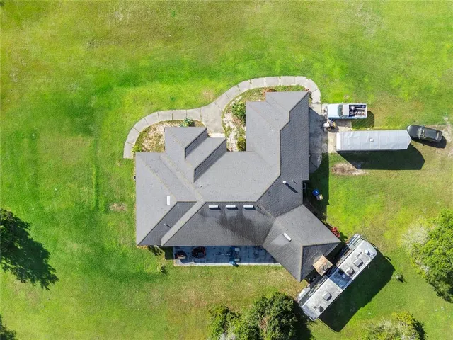 an aerial view of a house with a swimming pool and garden view