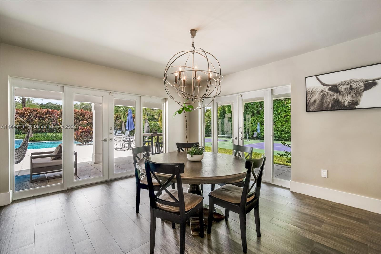 7900 Southwest 129th Terrace Pinecrest, FL 33156 - Photo 12 of 57 a view of a dining room with furniture wooden floor and chandelier