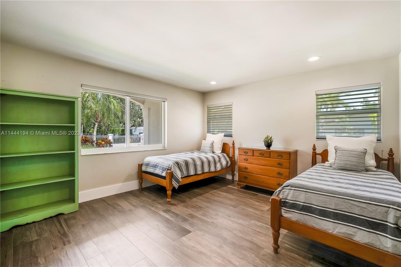 7900 Southwest 129th Terrace Pinecrest, FL 33156 - Photo 19 of 57 a bedroom with a bed wooden floor and window