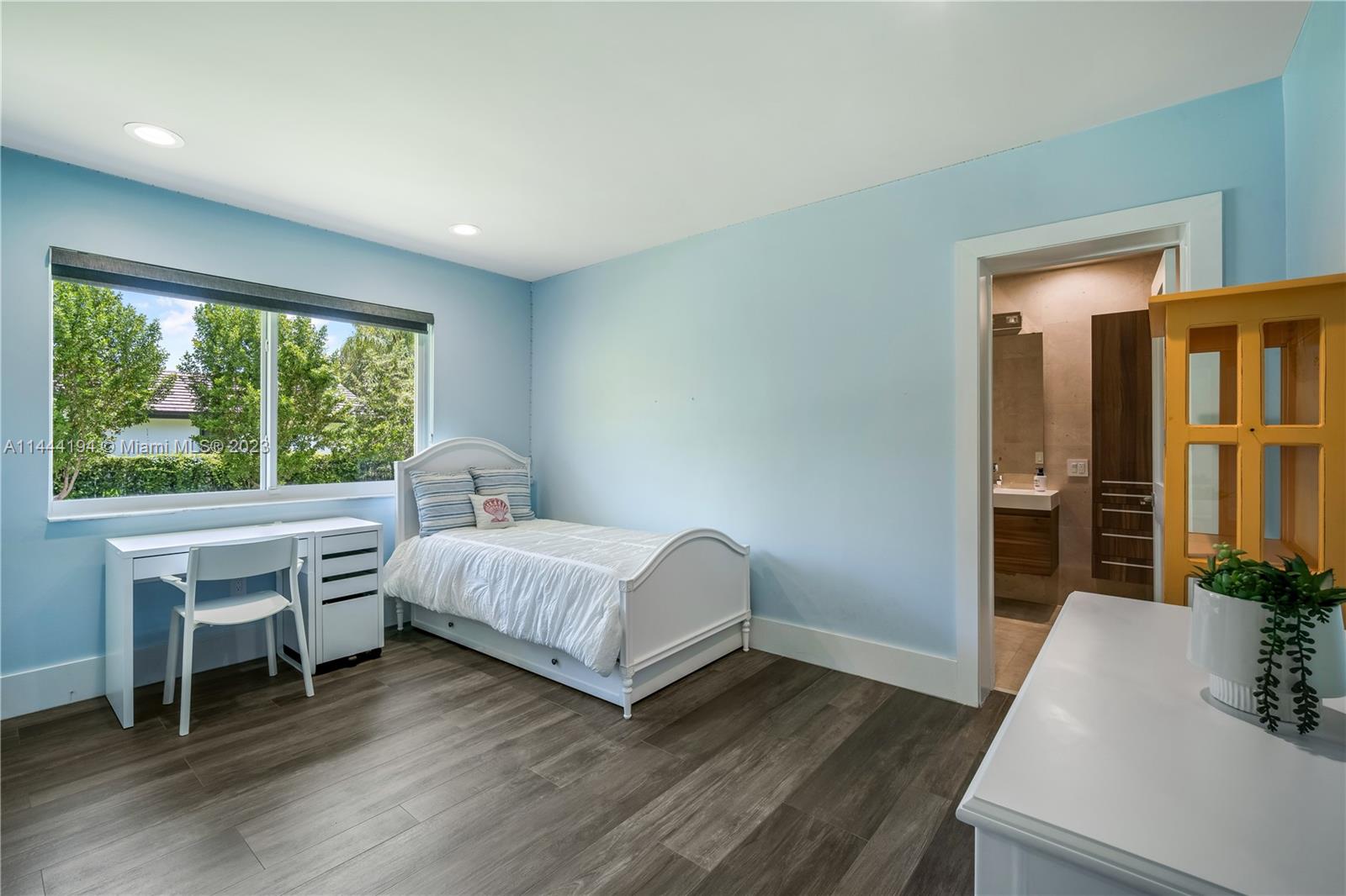 7900 Southwest 129th Terrace Pinecrest, FL 33156 - Photo 21 of 57 a spacious bedroom with a bed and a table in it