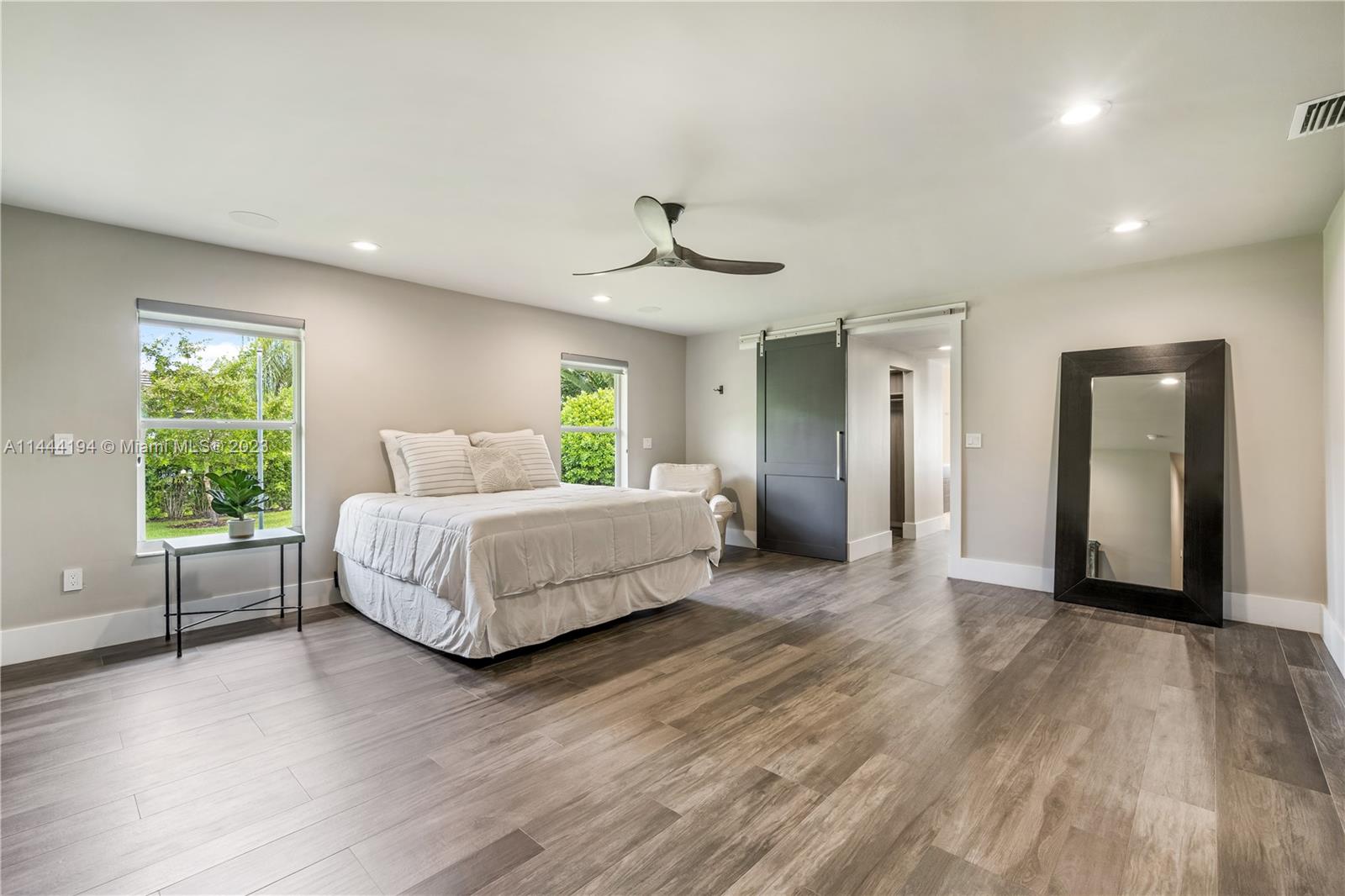 7900 Southwest 129th Terrace Pinecrest, FL 33156 - Photo 26 of 57 a bedroom with a large bed and a chandelier