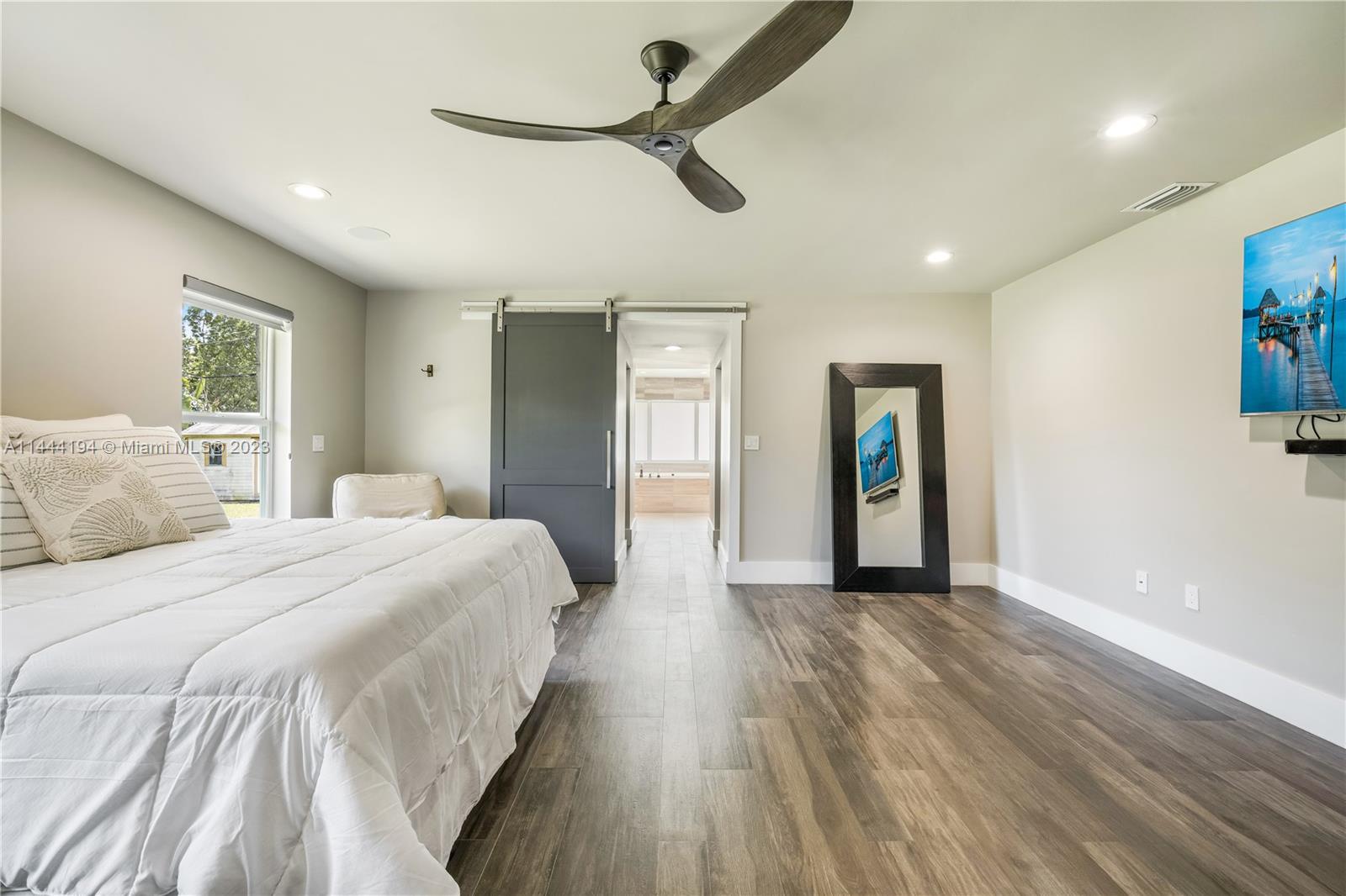 7900 Southwest 129th Terrace Pinecrest, FL 33156 - Photo 27 of 57 a spacious bedroom with a bed and a chandelier