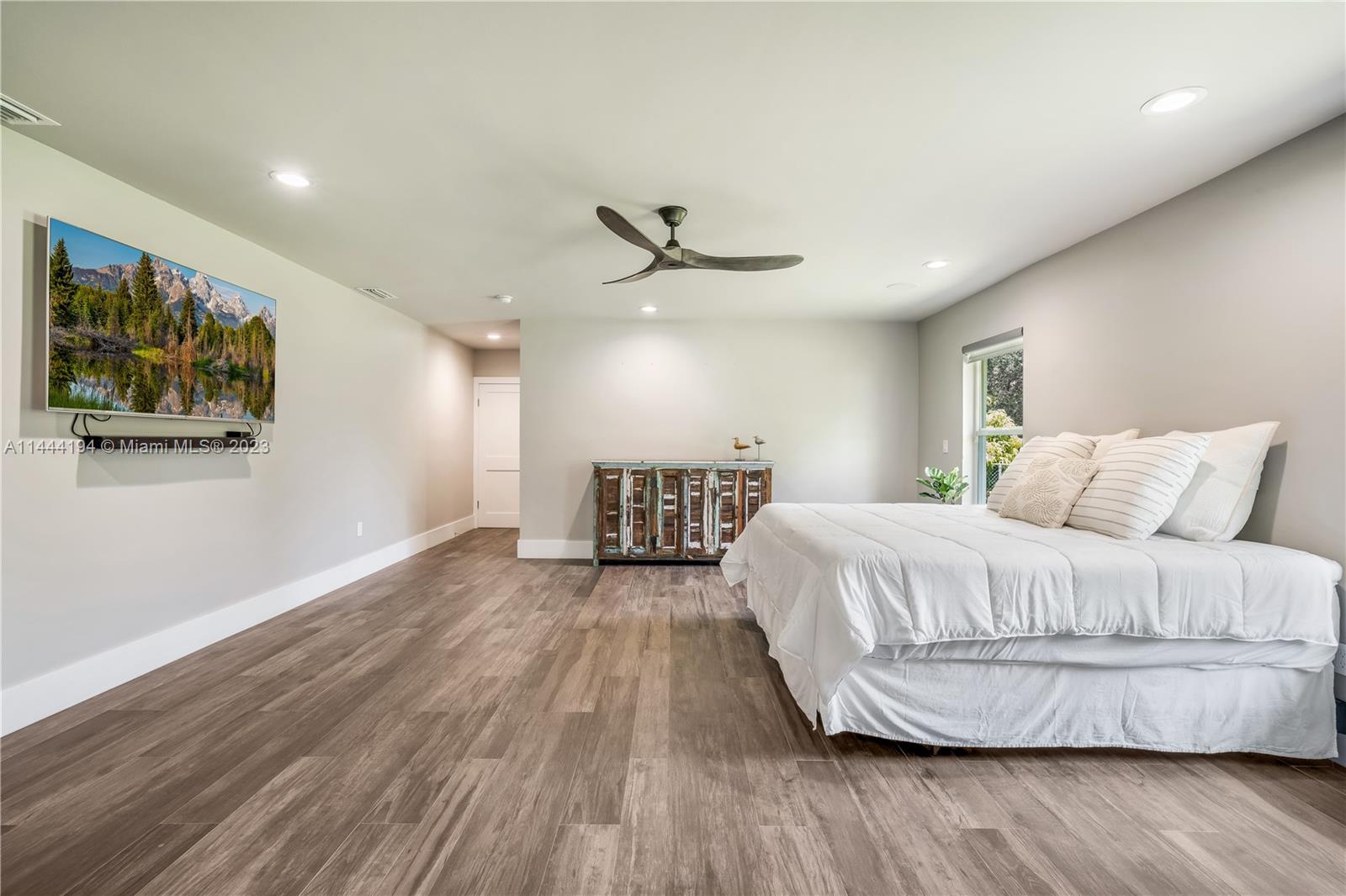7900 Southwest 129th Terrace Pinecrest, FL 33156 - Photo 28 of 57 a spacious bedroom with a bed and a ceiling fan