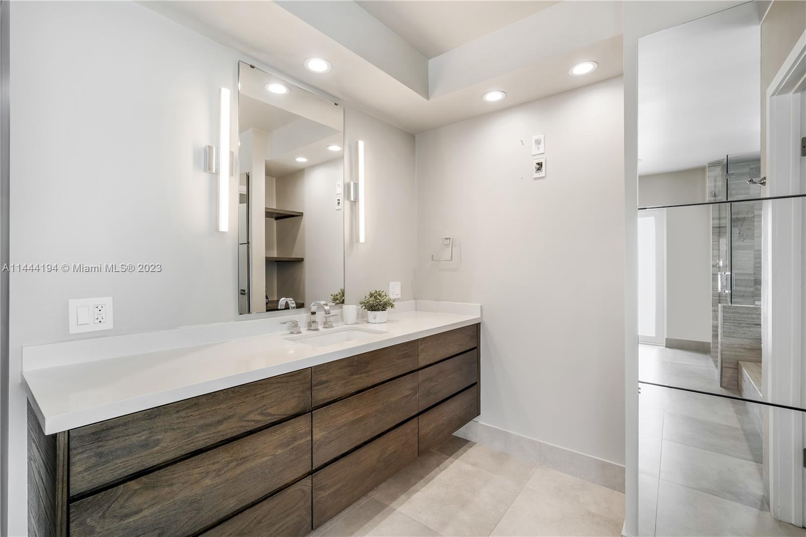 7900 Southwest 129th Terrace Pinecrest, FL 33156 - Photo 32 of 57 a bathroom with a double vanity sink mirror and double