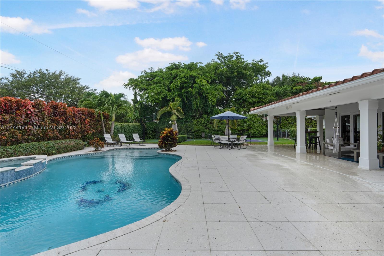 7900 Southwest 129th Terrace Pinecrest, FL 33156 - Photo 42 of 57 a view of a swimming pool with lounge chair