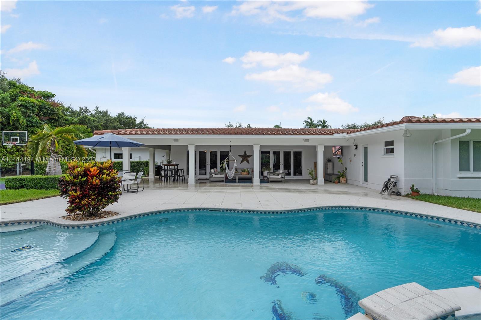 7900 Southwest 129th Terrace Pinecrest, FL 33156 - Photo 43 of 57 a view of a house with swimming pool and porch