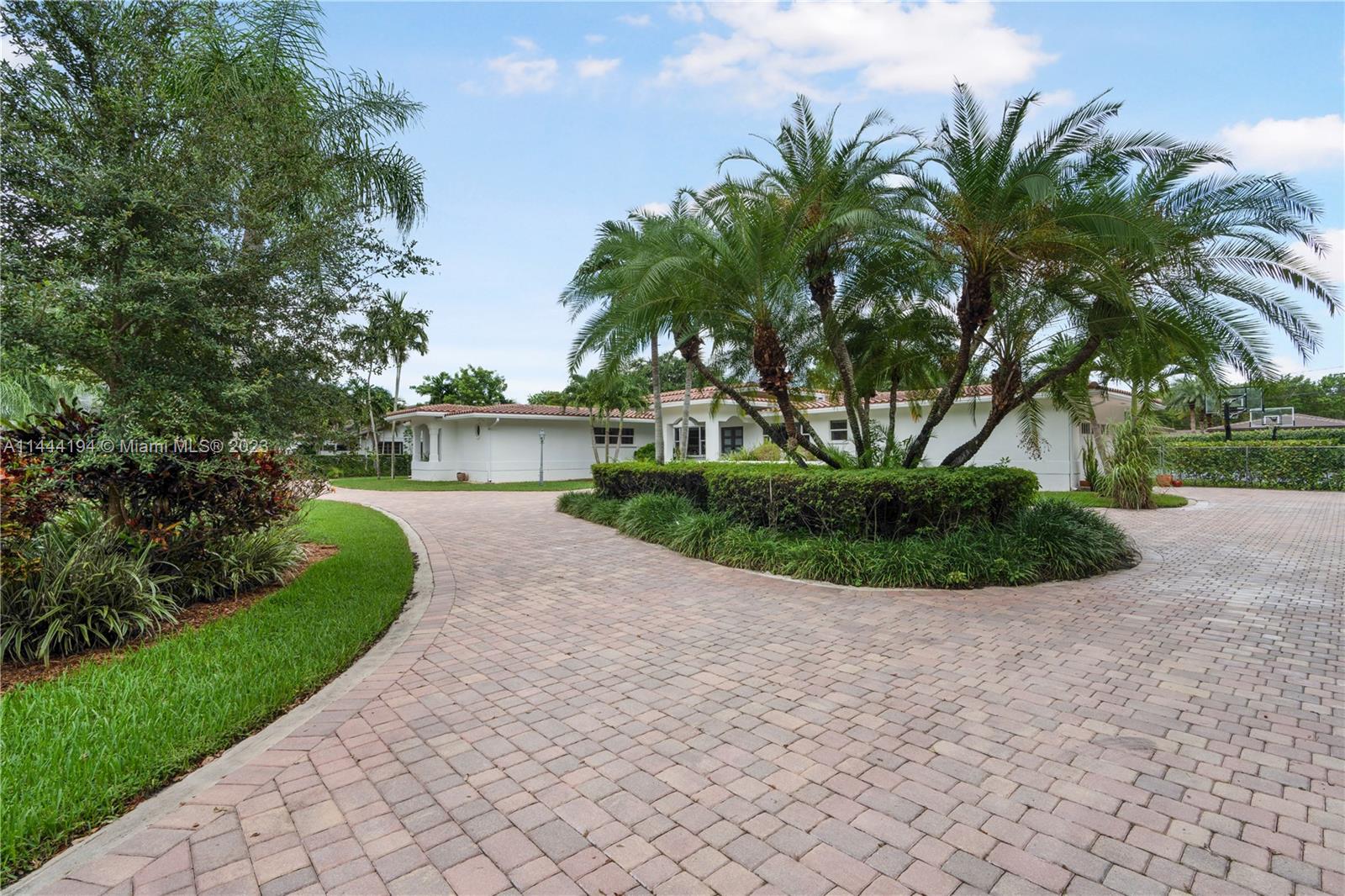 7900 Southwest 129th Terrace Pinecrest, FL 33156 - Photo 51 of 57 a front view of a house with garden and plants