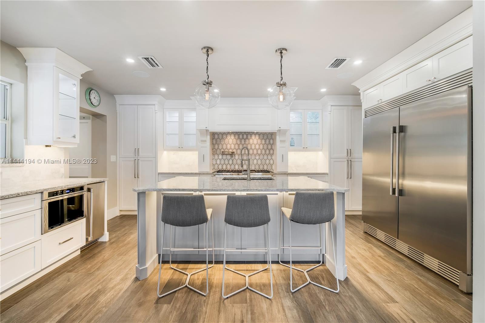 7900 Southwest 129th Terrace Pinecrest, FL 33156 - Photo 9 of 57 a large kitchen with granite countertop a stove and a wooden floor
