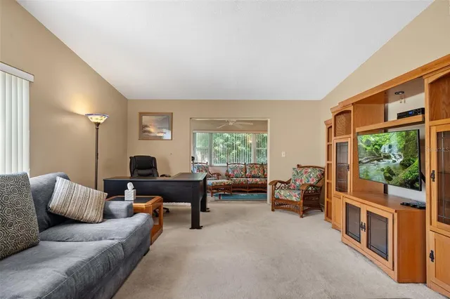 a living room with furniture a dining table and a large window