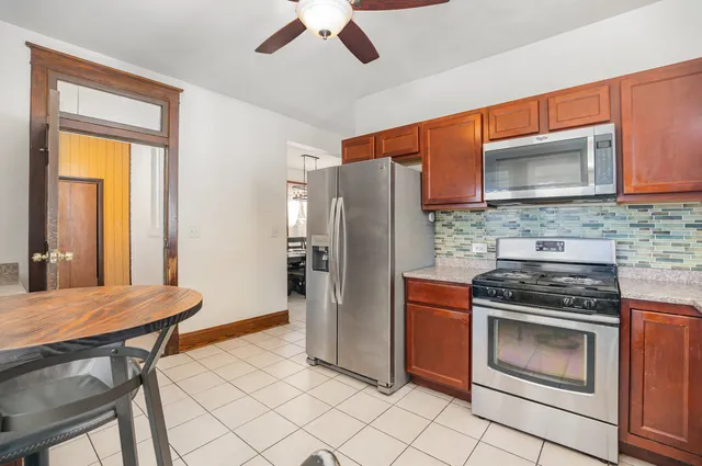 a kitchen with stainless steel appliances granite countertop a stove a refrigerator and a sink