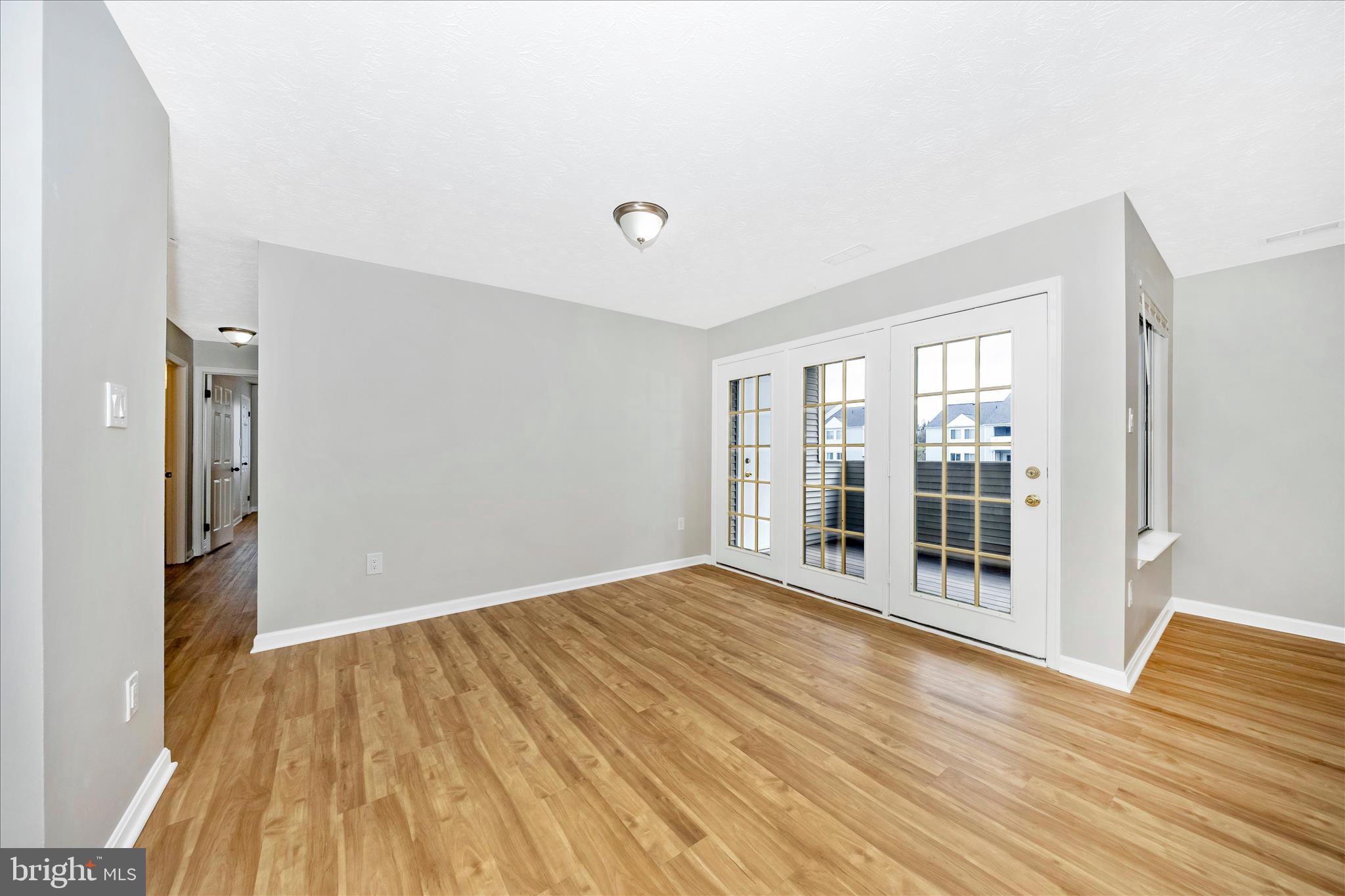 2137 Wainwright Court, Unit 1B Frederick, MD 21702 - Photo 11 of 55 a view of an empty room with wooden floor and a window