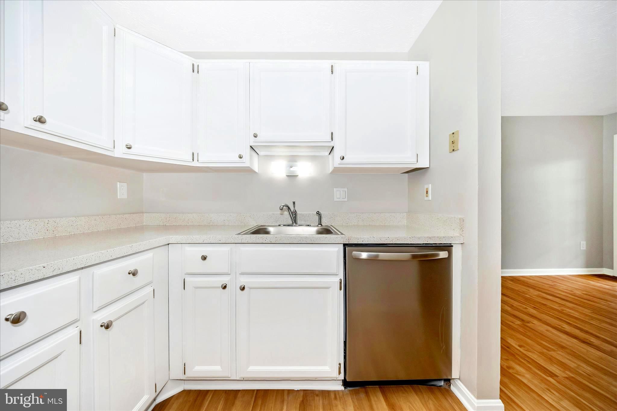 2137 Wainwright Court, Unit 1B Frederick, MD 21702 - Photo 19 of 55 a kitchen with granite countertop white cabinets and white appliances