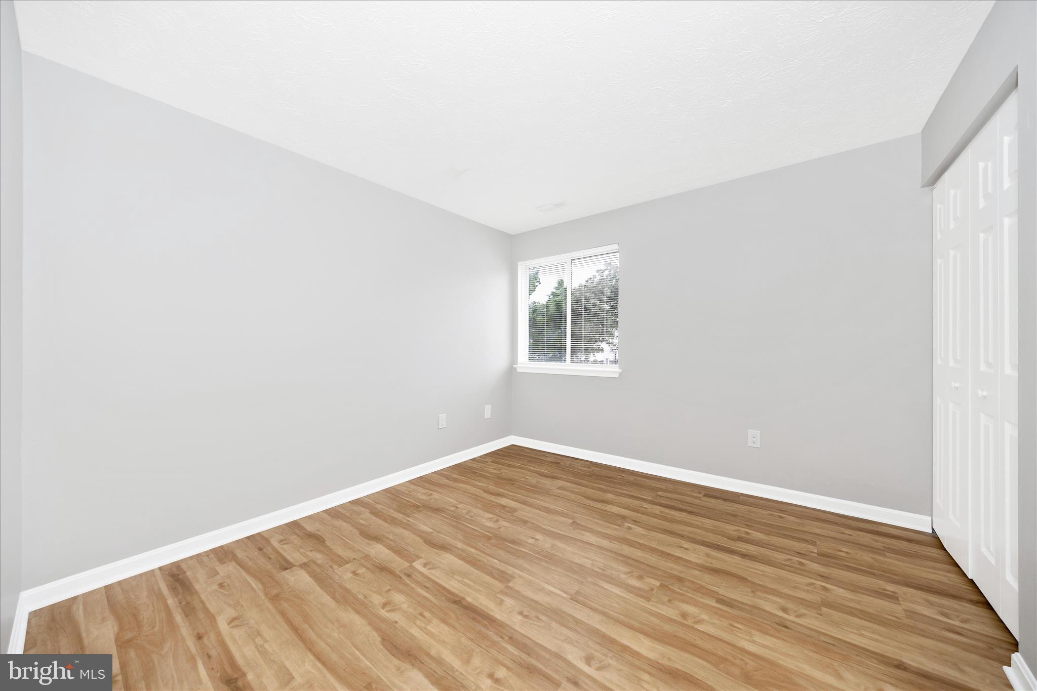 2137 Wainwright Court, Unit 1B Frederick, MD 21702 - Photo 32 of 55 an empty room with wooden floor and windows