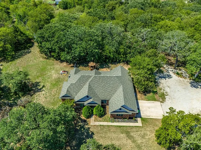an aerial view of a house with a yard and trees