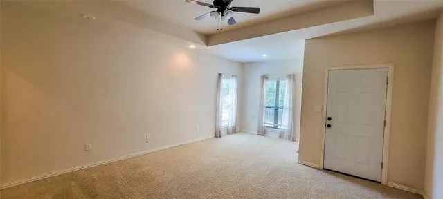 an empty room with a ceiling fan and a window